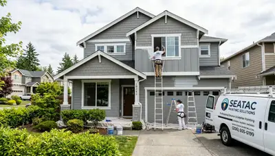 Professional house painters in Seattle WA applying exterior paint to a residential home